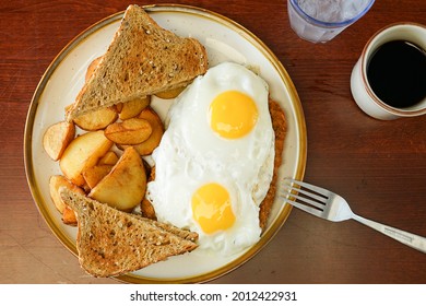 Chicken Fried Steak And Fried Eggs With Toast And Potatoes