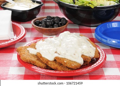 Chicken Fried Steak Smothered In Country Gravy On A Picnic Table