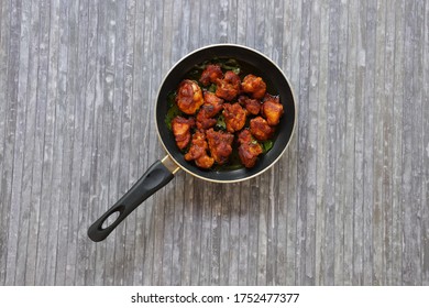 Chicken Fry Or Fried Chicken Kabab Which Is Well Garnished With Curry Leaves In A Black Frying Pan With Grey Background 