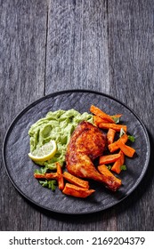 Chicken With Guasacaca Sauce Of Avocado, Green Pepper And Herbs And Sweet Potato Chips On Black Plate On Wooden Table, Vertical View From Above, Free Space