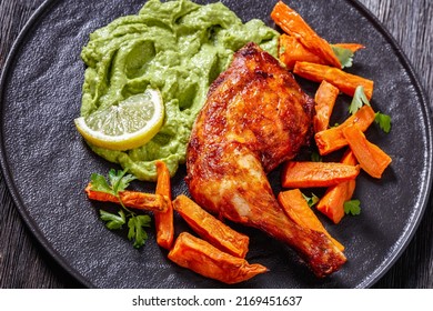 Chicken With Guasacaca Sauce Of Avocado, Green Pepper And Herbs And Sweet Potato Chips On Black Plate On Wooden Table, Horizontal View From Above, Close-up