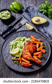 Chicken With Guasacaca Sauce Of Avocado, Green Pepper And Herbs And Sweet Potato Chips On Black Plate On Wooden Table, Vertical View From Above