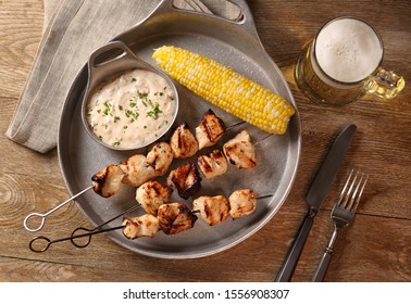 Chicken Kabobs With Corn On The Cob And Sauce On Metal Plate.