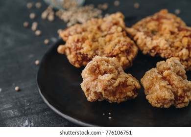 Chicken karaage japanese food in the black plate on grey concrete background with herb and flour