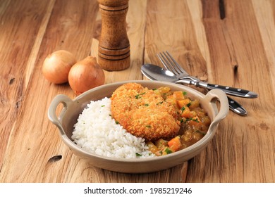 Chicken Katsu With Japanese Curry, Serve With White Rice On Brown Ceramic Plate Above Wooden Table