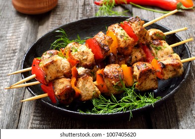 Chicken kebab with bell pepper in frying pan, close up