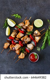 Chicken kebab on skewers with mushrooms and peppers and barbecue sauce on a black background. Food for a picnic.