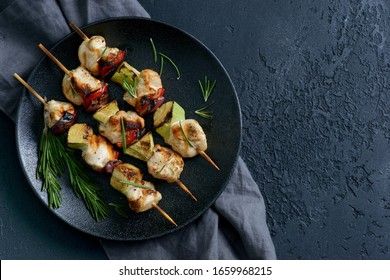 chicken kebab with vegetables on a dark background