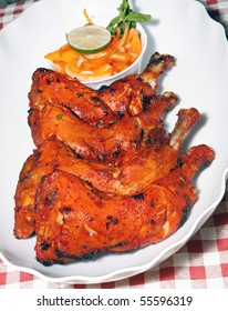 chicken legs in white plate with salad