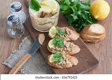 Chicken liver pate with white bread, lemon, parsley on wooden cutting board/Chicken liver pate
