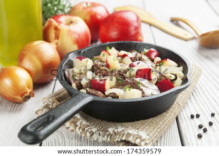 Chicken liver stewed with apples and onion in the frying pan 