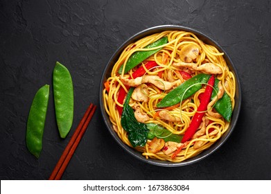 Chicken Lo Mein In Black Bowl At Dark Slate Background. Lo Mein Is Chinese Cuisine Dish With Chicken Meat, Egg Noodles, Vegetables And Sauces. Chinese Food. Stir Fried Noodles. Copy Space. Top View