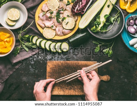 Similar – Image, Stock Photo Female hands making chicken skewers with vegetables for grilling