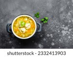 Chicken meatball soup in pot on dark background. Top view, copy space, flat lay.