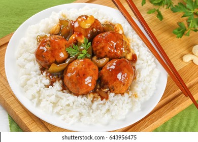 Chicken Meatballs Stewed  Green Bell Pepper, Onion, Soy Sauce, Chinese Cooking Wine And Spices Served On Basmati Rice On Plate On Wooden  Board With Chopsticks, View From Above, Close-up