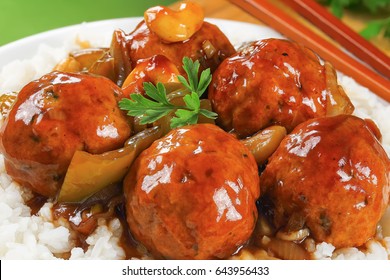 Chicken Meatballs Stewed In Sauce Of With Green Bell Pepper, Onion, Soy Sauce, Chinese Cooking Wine, Cashew Nuts And Spices Served On Basmati Rice On White Plate, View From Above, Close-up