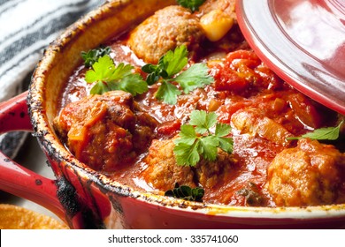 Chicken Meatballs In Tomato Sauce, Cooking In Red Casserole Dish.