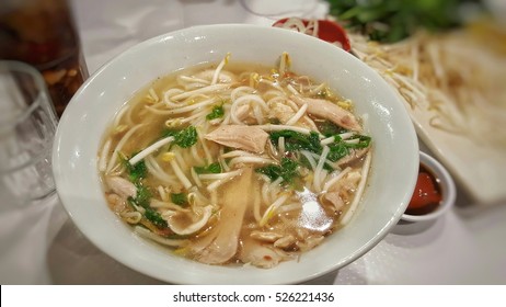 Chicken noodle with hot soup in a white bowl.Asia food