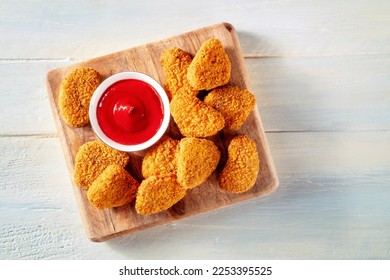Chicken nuggets with bbq sauce on a rustic wooden background, top shot. A crispy appetizer at a restaurant, finger food - Powered by Shutterstock - Get 15% off with code: PIKWIZARD15