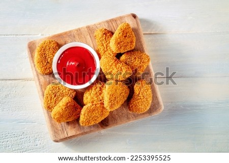 Chicken nuggets with bbq sauce on a rustic wooden background, top shot. A crispy appetizer at a restaurant, finger food