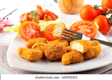 Chicken nuggets on dish on complex background