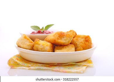 chicken nuggets with tomato sauce on a plate, white background