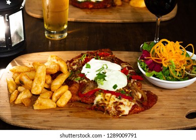 Chicken Parma With Chips And Salad On A Wooden Plate With Beer And Wine 