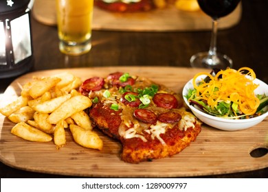 Chicken Parma With Chips And Salad On A Wooden Plate With Beer And Wine 