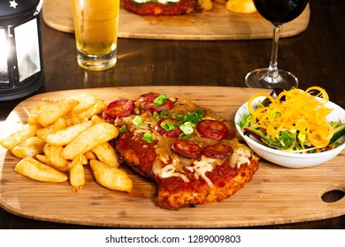 Chicken Parma With Chips And Salad On A Wooden Plate With Beer And Wine 