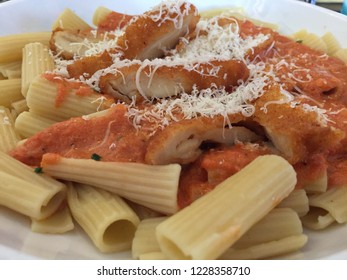 Chicken Parmesan Deconstructed: Breaded And Fried Chicken Cutlet Sliced And Served Over Rigatoni Pasta With Marinara Sauce And Grated Parmesan Cheese On White Plate