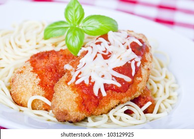 Chicken Parmigiana On A White Plate With Spaghetti