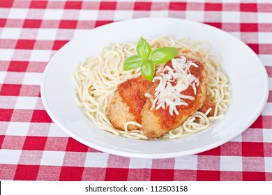 Chicken Parmigiana On A White Plate With Spaghetti