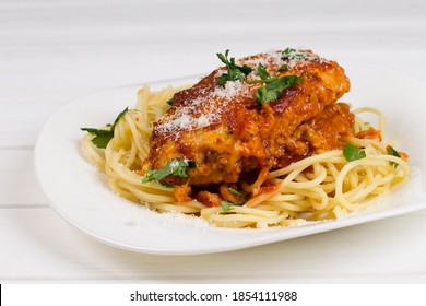 Chicken Parmigiana On A White Plate With Spaghetti