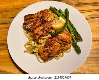 Chicken Piccata Served Over Linguine Pasta With Asparagus.