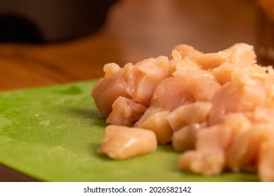 chicken pieces chopped up in a pile on a cuttingboard