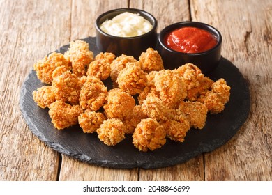 Chicken Popcorn are small slices of chicken that were coated breading and deep fried closeup in the slate dish on the table. Horizontal