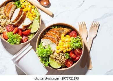 Chicken and quinoa salad with corn and tomatoes in a craft eco bowl, top view. Zero waste, to go food, recycling packaging, eco friendly concept.