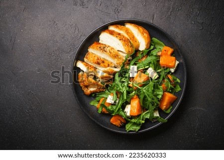 Chicken salad with pumpkin and arugula.