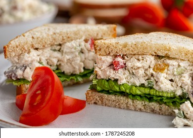 Chicken Salad Sandwich With Lettuce On Whole Wheat Bread Sliced In Half On A Plate