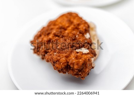 Chicken sandwich deep fried crispy meat on breakfast biscuit buns bread, fresh fast food on white plate at kitchen table plate macro closeup flat top view