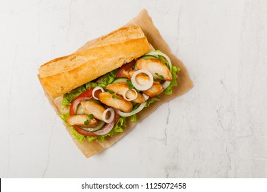 Chicken Sandwich With Tomato, Cucumber, Lettuce And Onions. White Stone Background. Top View. Flat Lay.