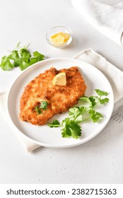 Chicken schnitzel on white plate