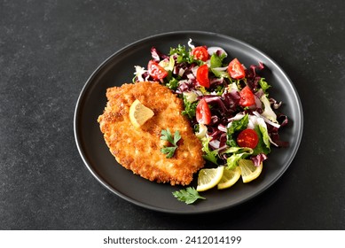 Chicken schnitzel and vegetable salad on plate 