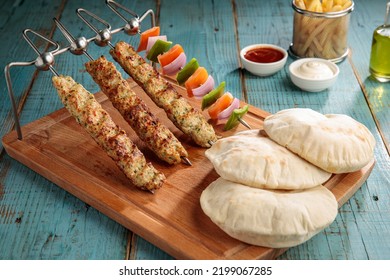 Chicken Seekh Kabab With Bread, Dip, Sauce And Fries Isolated On Cutting Board Side View On Table Fastfood