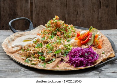 Chicken Shawarma Served On Large Pita Bread With Salads Tahini Sauce And Pickles