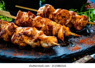 Chicken skewers - grilled meat with fresh vegetables on wooden background 