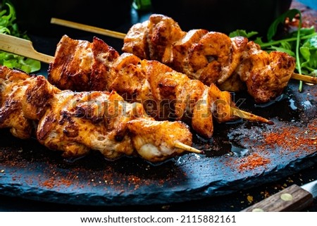 Chicken skewers - grilled meat with fresh vegetables on wooden background 