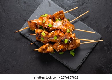 Chicken Skewers On Skewers On A Dark Table, Top View. Asian Style BBQ Chicken Pieces. Top View.