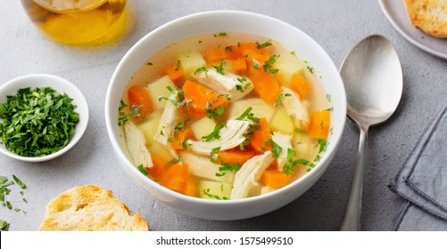 Chicken soup with vegetables in white bowl. Grey stone background. Close up. - Powered by Shutterstock