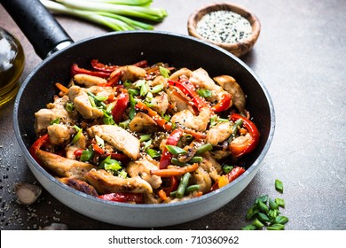 Chicken stir fry with   vegetables and sesame in the wok. Traditional asian food.